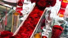 red roses and candles are arranged on the table for a formal function or wedding reception