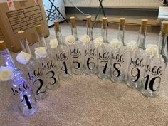 there are many bottles with flowers in them and numbers on the bottles that say each