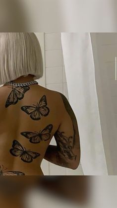 a woman with white hair and tattoos on her back