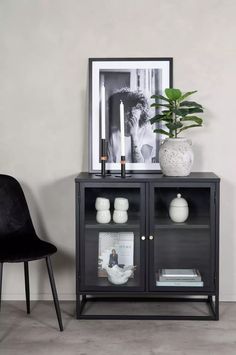 a black and white photo sitting on top of a wooden cabinet next to a chair