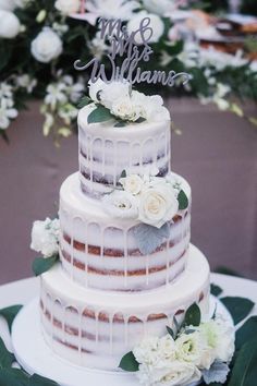 a wedding cake with white flowers and greenery