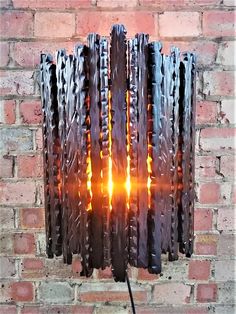 a lamp made out of old tires sitting on top of a brick wall