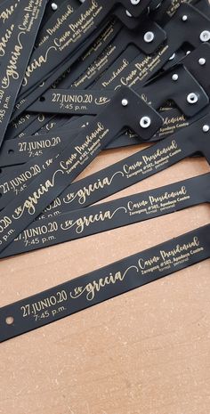 there are many black and gold name tags on the brown paper with white writing that says,