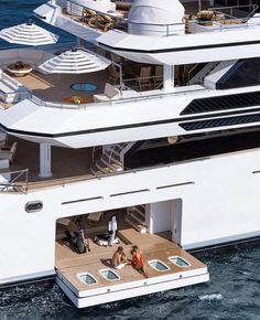 two people are sitting on the deck of a large white boat in the middle of the ocean