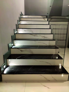 a set of stairs with marble treads and glass balconies