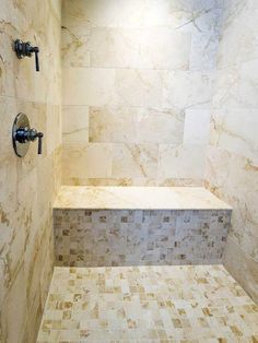 a walk in shower sitting next to a tiled wall