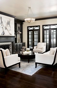 a living room filled with furniture and a painting hanging on the wall above it's fireplace