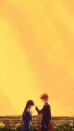 two people standing next to each other in front of a yellow sky