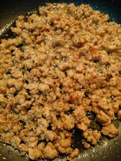 meat is cooking in a wok on the stove with some seasoning around it