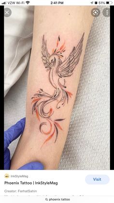 a tattoo on the arm of a woman with an orange and black bird in it