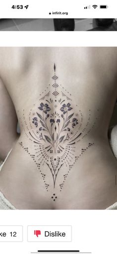 the back of a woman's stomach with an intricate tattoo design on her side