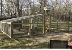 a person sitting in a chair next to a chicken coop