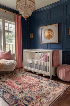 a baby's room with blue walls, pink curtains and a rug on the floor