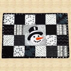 a patchwork quilt with a snowman on it's face and black and white squares