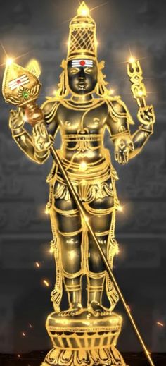 the golden statue is holding a gold object in his hand and standing on top of it