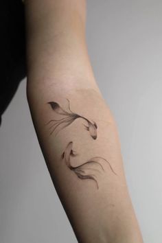 a woman's arm with a tattoo on it that has two birds flying in the air