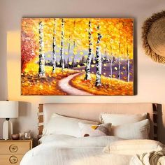 a painting hanging above a bed in a bedroom