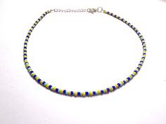 This super cute necklace is handmade with royal blue, baby blue, and yellow seed beads. It is a bestseller at my in person shows! It is perfect for summer, fall and all year round! Each necklace is made with additional extender chain, making it easily adjustable. Reach out with any questions! Blue Tiny Beads Choker For Summer, Yellow Tiny Beads Choker As Gift, Yellow Tiny Beads Choker For Gift, Adjustable Yellow Choker With Tiny Beads, Blue Choker With Tiny Round Beads, Blue Choker With Tiny Beads, Blue Tiny Beads Choker For Beach, Nebula Necklace, Summer Choker