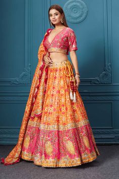 Dance like a diva on sangeet, mehendi, and wedding in this gorgeous orange bandhej print silk lehenga with gotta patti work and beautifully decorated borders. Featuring with a beautiful V neck and 3/4th sleeve blouse. Shop online at Pure Elegance or visit our store in the USA.