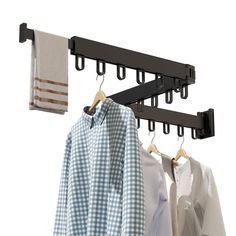 two shirts hanging on clothes racks with towels in the background and one shirt hung up to dry