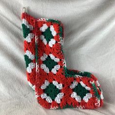 a pair of crocheted leg warmers on top of a white bed sheet