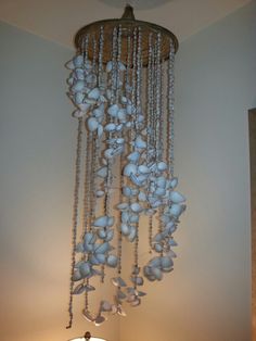 a chandelier with shells hanging from it's sides in a living room