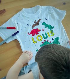 Looking for the perfect gift for your young Dinosaur lover's birthday? Look no further than our personalised dinosaur colour-in t-shirt! Made from high-quality, soft cotton, this t-shirt features a fun and engaging dinosaur design that your child will love. Plus, with the included fabric markers, your child can customise the shirt with their favorite team colors or designs. Our t-shirt is available in a range of sizes, from toddler to youth, so your child can enjoy it for years to come. And beca White T-shirt With Dinosaur Print For Birthday, Birthday Look, Dinosaur Coloring, Love Plus, Dinosaur Design, Fabric Markers, Dinosaur Birthday, Kids Tops, Team Colors