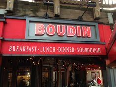 the entrance to boudiin restaurant with red awnings and people sitting at tables outside