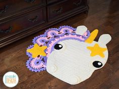 a crocheted rug with a unicorn's head and stars on the top