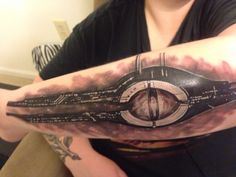 a woman with a tattoo on her arm has an image of a spaceship in the sky