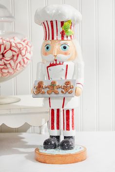 a christmas nutcracker holding a tray of pretzels on a white table