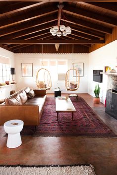 a living room filled with furniture and a fire place in the middle of an open floor plan