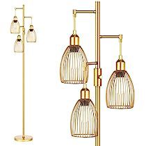 the three light floor lamp is gold and has four glass shades on each side, along with