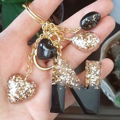 a person holding onto some black and gold charms