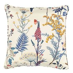 a white pillow with blue and yellow flowers on the front, and a red bird sitting on