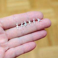 three tiny miniature figurines are sitting on someone's hand, one is holding the other