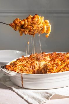 a person is lifting some food out of a casserole dish