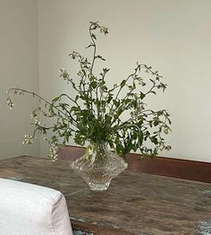 a vase filled with flowers sitting on top of a wooden table