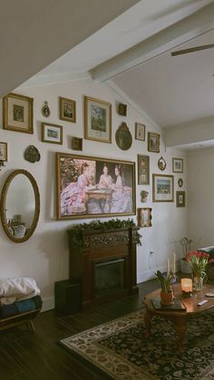 a living room filled with furniture and framed pictures on the wall above a fire place