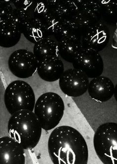 black balloons with white writing on them and numbers written on them are arranged in rows