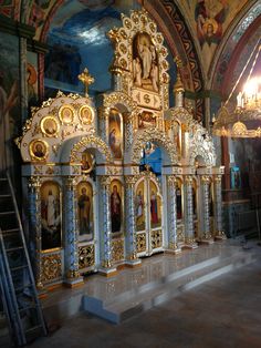 an ornate alter in a church with paintings on the walls and gold trimmings