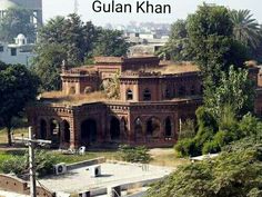 an old building in the middle of a city with trees and buildings around it,