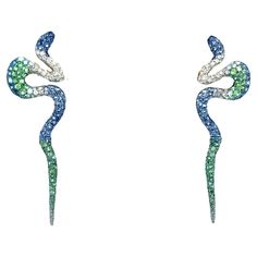 18K White Gold Green Garnet & Sapphire Earrings with Diamonds 144 Blue Sapphires - 1.65 CT 144 Diamonds - 0.80 CT 152 Green Garnets - 1.26 CT 18K White Gold - 6.69 GM These stunning 18K white gold earrings feature a total of 144 blue sapphires, totaling 1.65 carats, alongside 144 diamonds totaling 0.80 carats, and 152 green garnets totaling 1.26 carats. The unique design showcases a serpent-like shape, exuding elegance and sophistication. The combination of vibrant gemstones and the lustrous white gold setting creates a captivating contrast, making these earrings a true statement piece. Perfect for adding a touch of luxury and glamour to any ensemble, these earrings are a timeless addition to any jewelry collection. Green Snake, Green Garnet, White Gold Set, Green Home Decor, Snake Earrings, White Gold Earrings, Sapphire Earrings, Jewelry Inspo, Showcase Design