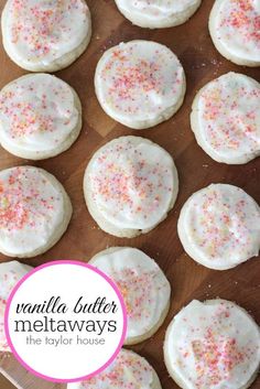 cookies with white frosting and sprinkles on a cutting board