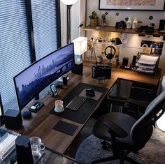 a desk with a computer monitor, keyboard and mouse on it in front of a window