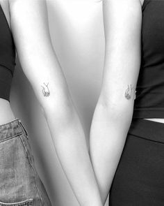 two people with matching tattoos on their arms