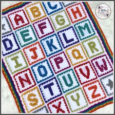 a crocheted alphabet blanket with letters and numbers on it, in multicolors