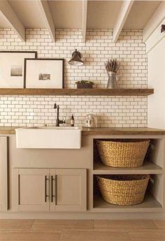 a kitchen with white brick walls and open shelving above the sink is filled with wicker baskets