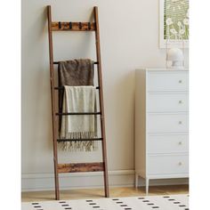 an old wooden ladder leaning against a wall in a room with a rug and dresser