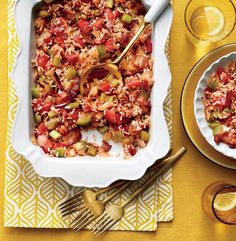 a casserole dish with rice and vegetables in it on a yellow table cloth